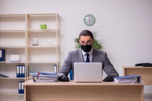 man at desk with mask