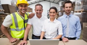 Diverse team in a warehouse with a laptop open